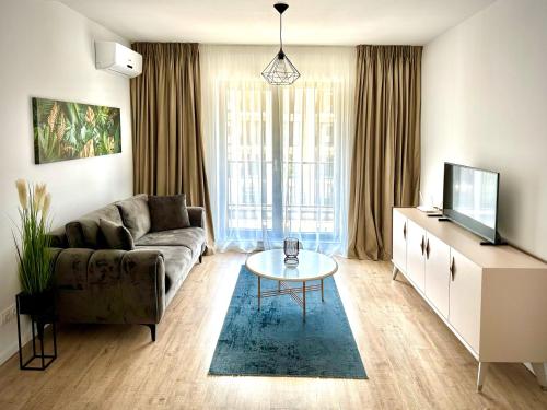 - un salon avec un canapé et une table dans l'établissement Vlad Rentals Properties, à Voluntari
