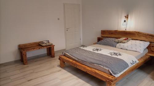 a bedroom with a wooden bed and a table at Zimmerferi Apartman Keszthely in Keszthely