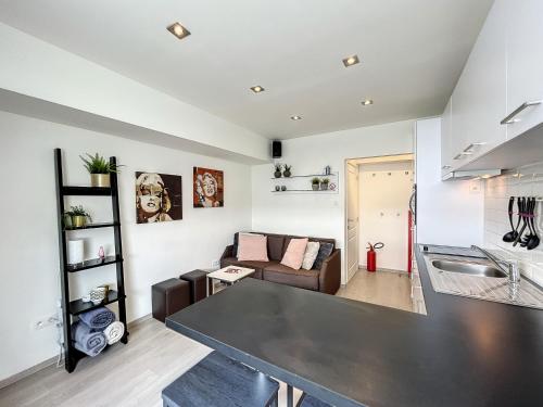 a kitchen and living room with a table and a couch at Vakantieverblijf Monopole Oostende in Ostend