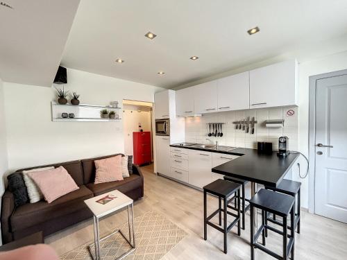 a kitchen and living room with a couch and a table at Vakantieverblijf Monopole Oostende in Ostend