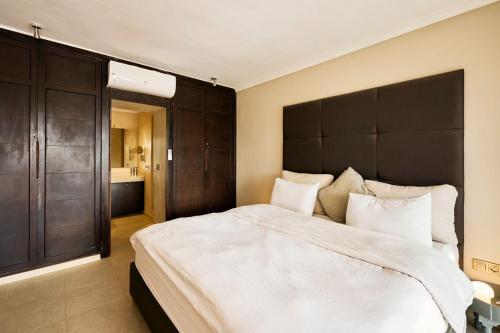 a bedroom with a large bed with a large black headboard at Dar Meha in Marrakech