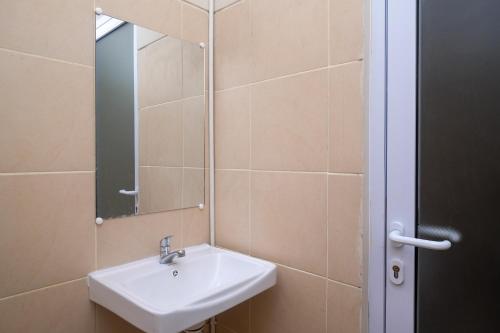 y baño con lavabo y espejo. en RedDoorz Plus near RS JIH Solo, en Solo