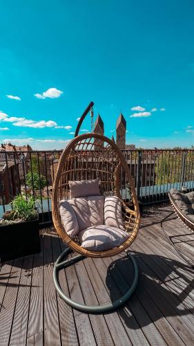 a wicker chair sitting on top of a deck at Seven Hotel Bytom - Katowice in Bytom