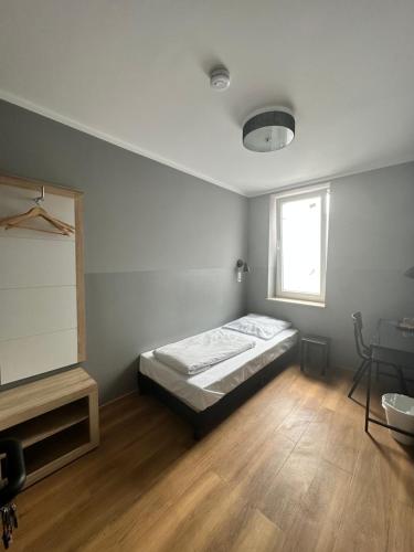 una camera con letto, scrivania e finestra di Hotel Fly ´ In a Offenbach