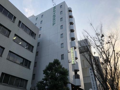 un edificio blanco con un cartel en el costado en Hotel il Grande Umeda, en Osaka