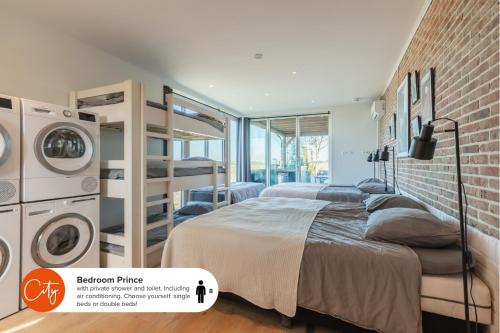 um quarto com uma cama ao lado de uma parede de tijolos em 10 min to Amsterdam! 20 beds, Jacuzzi, & Disco! em Zwanenburg