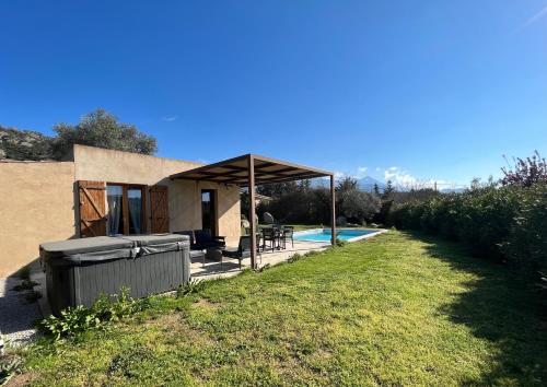 une maison avec un pavillon à côté d'une piscine dans l'établissement Villa CAlisti, à Belgodère