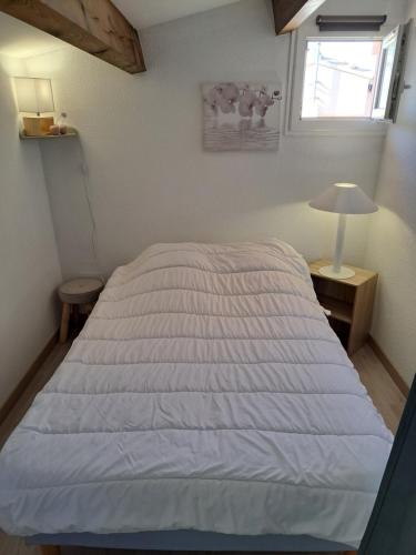 une chambre avec un lit, une lampe et une fenêtre dans l'établissement Maisonnette, 5 Pers, 500m plage, Parking, Terrasse, au Cap d'Agde