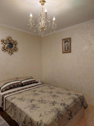 sypialnia z łóżkiem i żyrandolem w obiekcie EL Mar Sole w mieście Eforie Sud