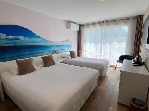 una camera d'albergo con due letti e una grande finestra di Hotel Europe a La Grande-Motte