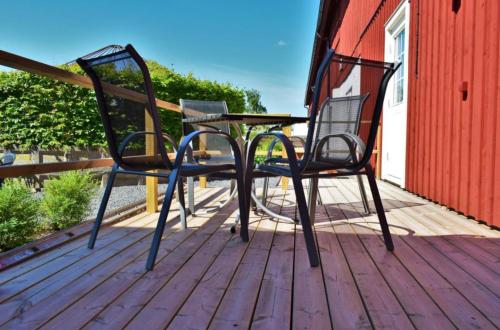 two chairs and a table on a deck at Närebo Gårdshotell & Restaurang in Lidköping
