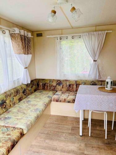 - un salon avec un grand canapé et une table dans l'établissement La Louée du canal, à Braux