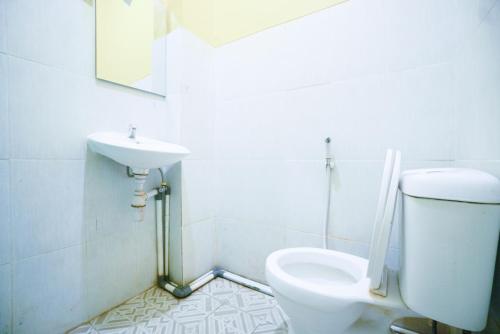 y baño con aseo y lavamanos. en Mahkota Sivali near Soekarno Hatta Airport Mitra RedDoorz, en Tangerang