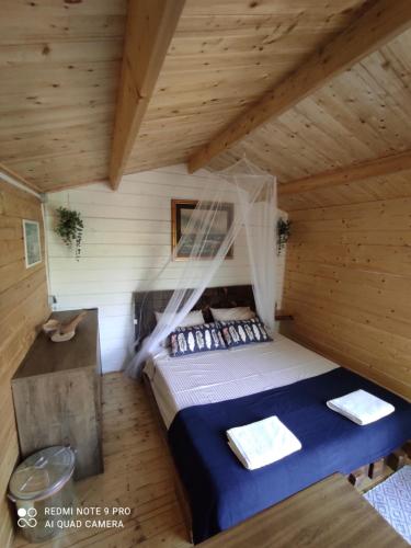 - une chambre avec un lit dans une cabane en bois dans l'établissement Paradise kosirina, à Murter