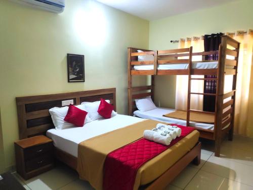 a bedroom with two bunk beds with red pillows at Golden Peak Estate Homestay in Wayanad