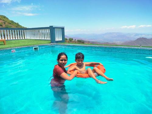 a woman and a child in a swimming pool at Hilltop Resort and Glamping Wai, Near Panchgani in Wai