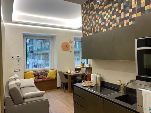 eine Küche mit einem Sofa, einem Stuhl und einem Tisch in der Unterkunft Civico Cinque Home Luxury Apartment in Salerno