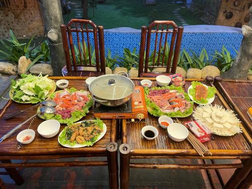 a wooden table with plates of food on it at Sapa Bamboo Eco in Sa Pa