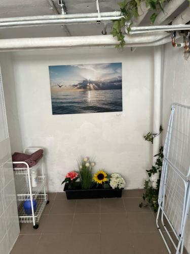 a room with flowers on a wall with a picture at Cosy compact living best for 1-2 adults in Heberg