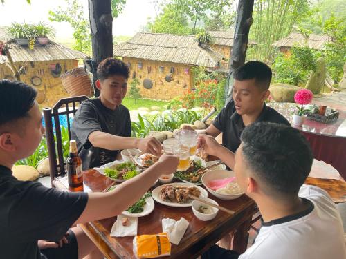 a group of men sitting around a table eating food at Sapa Bamboo Eco in Sa Pa