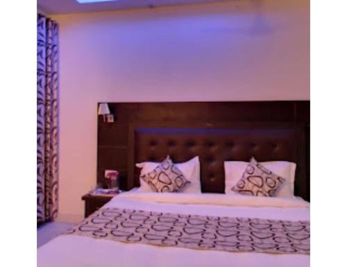 a bedroom with a large bed with a wooden headboard at Hotel lords Highway Inn, Gagal Khas in Kangra