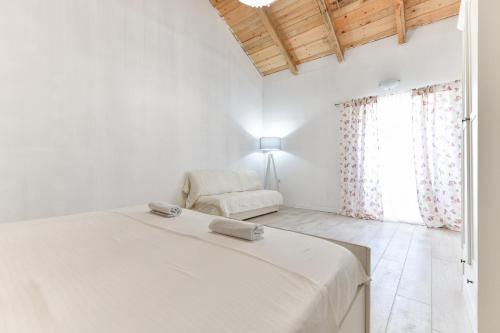 - une chambre blanche avec un lit et une chaise dans l'établissement Villa Martin, à Zadar