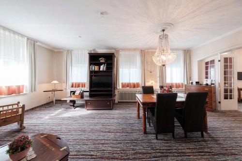ein Wohnzimmer mit einem Tisch und einem Esszimmer in der Unterkunft Hotel Haus Duden in Wesel
