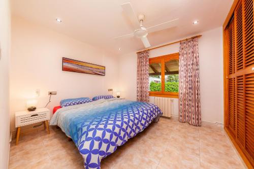 een slaapkamer met een bed en een raam bij Na Forana Cala Ratjada in Cala Ratjada