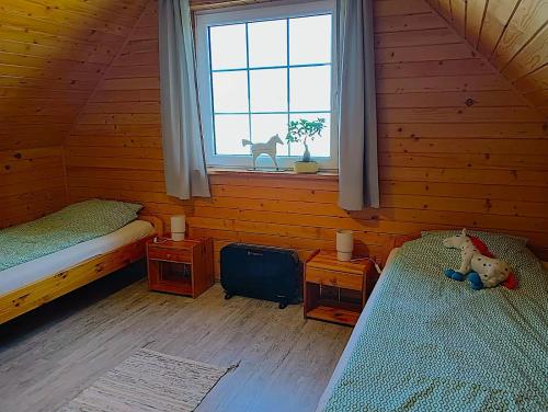 a room with two beds in a log cabin at Agroturystyka - Stajnia Bursztynowa in Puck