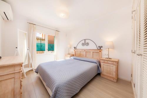 Schlafzimmer mit einem Bett, einem Schreibtisch und einem Fenster in der Unterkunft Ca Na Aina in Cala Millor