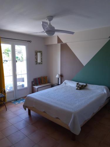 - une chambre avec un lit et un ventilateur de plafond dans l'établissement Gite La RESTANCO, à Mouriès