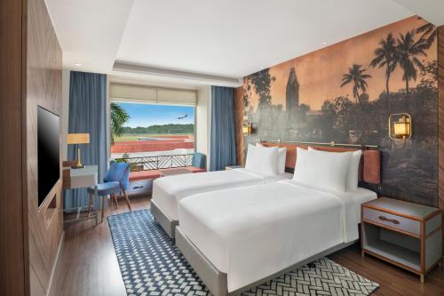 a hotel room with two beds and a balcony at Radisson Blu Hotel & Suites GRT Chennai in Chennai