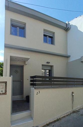 ein großes weißes Haus mit einem Zaun davor in der Unterkunft Doukas Home in Mytilini