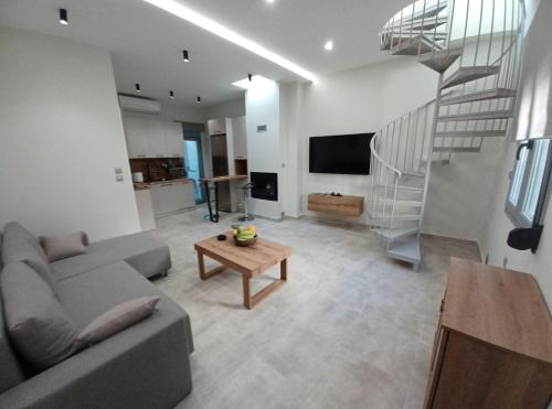 a living room with a couch and a table and a staircase at Doukas Home in Mytilini