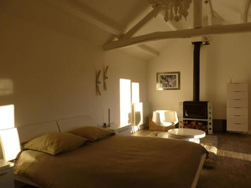 ein Schlafzimmer mit einem großen Bett und einem Stuhl in der Unterkunft Hameau en cévennes Location Gîte de luxe in Saint-Étienne-Vallée-Française