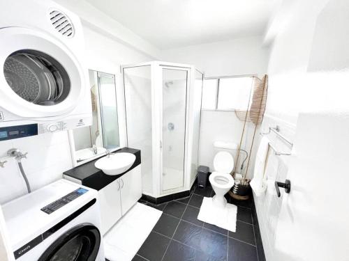 a white bathroom with a toilet and a sink at Gladstone Gem 3 - Suva CBD 2bd Apt in Suva