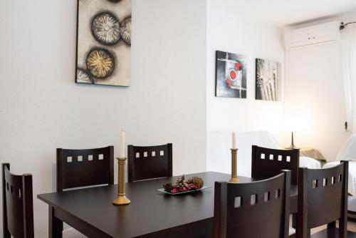 a dining room with a table and chairs with a candle at Vejer 1 - Andalmar in Vejer de la Frontera