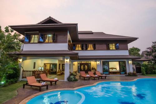 a house with a swimming pool in front of a house at Oriental Thai luxury villa with Private pool in Chiang Mai