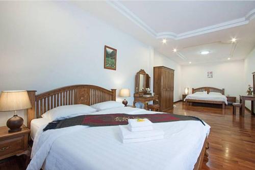 a large bedroom with a large white bed with white sheets at Oriental Thai luxury villa with Private pool in Chiang Mai