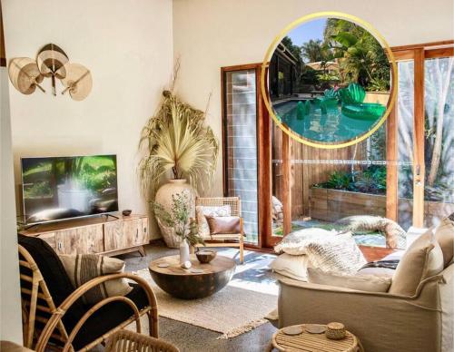 a living room with a large mirror and a pool at Beach Jungle - Hot Tub, Firepit & Pool in Beachside Oasis in Byron Bay