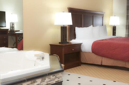 a hotel room with a bed and a lamp at Country Inn & Suites by Radisson, Macedonia, OH in Macedonia