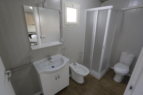 Baño blanco con lavabo y aseo en Tropical Casette Residence en Diamante
