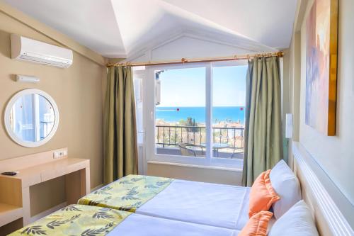 a bedroom with a bed and a view of the ocean at Akdora Elite Hotel & Spa in Side