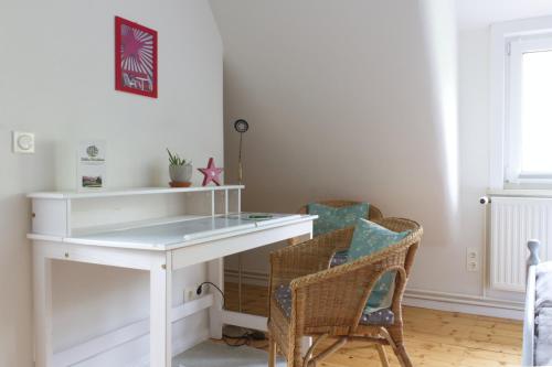 a white desk in a room with chairs at Villa Viriditas in Elbingerode