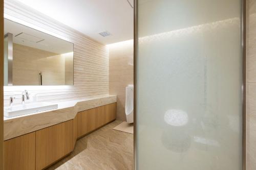 a bathroom with a sink and a toilet and a mirror at Kinzan in Kobe
