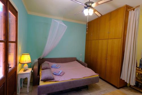 a bedroom with a bed with a blue wall at little house in forest in Kalymnos