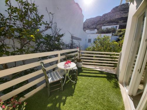 a small table and chair on a balcony with a mountain at Antonios 1 in Matala