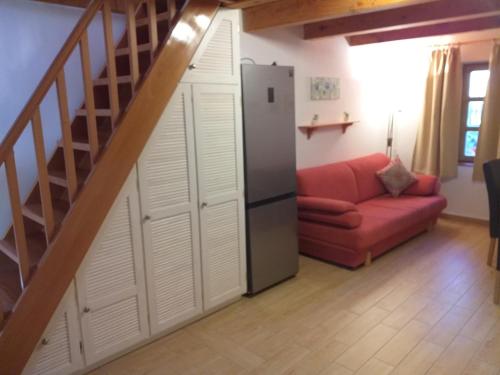 a living room with a refrigerator and a red couch at Mézes-Kuckó in Tihany