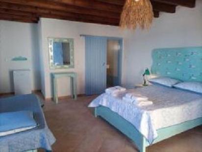 a bedroom with a blue bed and a couch at ΠΑΡΑΘΙΝ ΑΛΟΣ 2 in Skiros