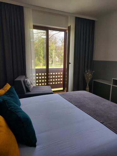 Un dormitorio con una cama grande y una ventana en Apartman Stella Rossa, en Palić